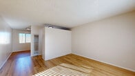 Located at 12534 S Inglewood Ave in Hawthorne, California, this efficiently designed single-floor unit offers a clean, neutral aesthetic with practical functionality throughout. The living room is an open, airy space featuring warm wood-look flooring, crisp white walls, and a textured ceiling. Natural light streams in through window blinds, casting bright, linear patterns across the floor and creating a welcoming ambiance. The layout, as seen in the dollhouse view, flows cohesively from the living area into the kitchen. The kitchen is thoughtfully appointed with white cabinetry — both upper and lower — a gas range, a stainless steel sink, and light countertops. A large window with vertical blinds allows ample natural light to fill the space, enhancing its clean, functional character. The wood-look flooring continues seamlessly from the living area into the kitchen, providing a consistent and cohesive look. The unit also includes a dedicated closet for storage and two bathrooms, one of which features a clean, all-white tub and shower surround with a built-in shelf niche. The overall design is minimal and move-in ready, making it a practical and comfortable space in the South Bay area of Los Angeles County.