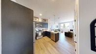 Located at 80 Batterson Park Road in Farmington, CT, this thoughtfully designed one-bedroom, one-bathroom residence offers a modern aesthetic with clean lines and a neutral palette throughout. The open-concept kitchen and living area serves as the heart of the home, where the kitchen impresses with dark cabinetry, stainless steel appliances, a gas range, a white quartz peninsula with bar seating, and pendant lighting above — all set atop warm light hardwood flooring. The living area flows naturally from the kitchen and features a large window that invites natural light and outdoor views, creating a bright and welcoming atmosphere. The bedroom is a comfortable retreat, carpeted in plush blue tones, with a sizable window framing views of the surrounding greenery. It connects directly to a walk-in closet with multi-level wire shelving and hanging space, offering generous storage. The full bathroom is finished in a crisp, contemporary style with large-format tile, a soaking tub with shower, a floating wood vanity, and an oversized mirror. White walls and recessed lighting are consistent throughout, lending the entire residence a cohesive, modern feel well-suited to everyday living.