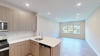 Located at 357 Dover Road in Toms River, NJ, this thoughtfully designed single-floor residence offers a well-organized layout comprising one bedroom, three bathrooms, two closets, and a connecting hallway. Light wood flooring flows consistently throughout, giving the home a clean, cohesive aesthetic.

The open-concept kitchen and living area serves as the heart of the home. The kitchen is outfitted with flat-front light wood cabinetry extending to the ceiling, white quartz countertops, a subway tile backsplash, and a full suite of stainless steel appliances including a gas range, over-the-range microwave, and a French door refrigerator. A peninsula with an integrated sink provides additional prep space and defines the transition into the living area.

The bedroom features large windows that invite generous natural light and offer views of greenery outdoors, complemented by recessed lighting and light wood flooring. Two closets, including a spacious walk-in with wire shelving, provide ample storage.

The three bathrooms are finished in a consistent modern palette. Large-format gray tile flooring, light wood vanities with white quartz countertops, and frameless glass shower enclosures with white subway tile contribute to a polished, contemporary feel throughout. Neutral wall tones and recessed lighting complete the refined, move-in-ready presentation of this Toms River residence.