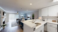 Located at 4580 Barclay Dr in Dunwoody, GA, this well-appointed single-floor residence offers 2 bedrooms, 2 bathrooms, and two flexible office spaces within a thoughtfully designed layout. The open-concept kitchen and living area serves as the heart of the home, featuring white shaker cabinetry, stainless steel appliances including a range, microwave, and dishwasher, a classic subway tile backsplash, light quartz countertops, and a breakfast bar peninsula. Wood-look flooring flows throughout the main living areas, complemented by crown molding and a ceiling fan in the living room, which is bright and welcoming. The primary bedroom offers comfortable proportions, plush carpeting, a sliding glass door with access to the outdoors, and a walk-in closet with built-in shelving and hanging rods. Both bathrooms are finished with white tile tub-shower combinations and brushed nickel fixtures. The two additional flex rooms feature carpet flooring, ceiling fans, and natural light from window blinds, making them well-suited as home offices or guest spaces. The neutral gray palette throughout creates a clean, cohesive aesthetic that lends itself to a variety of interior styles.