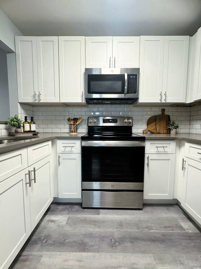 Modern Kitchen with Stainless-Steel Appliances, Quartz Countertops & Subway Tile Backsplash - Bridlewood