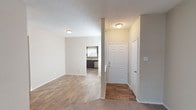 This single-story residence offers a practical and comfortable layout designed with everyday living in mind. The entryway welcomes you with rich wood-style flooring that extends through the main living and kitchen areas, creating a cohesive and easy-to-maintain foundation throughout the common spaces.

The open living area flows naturally toward the kitchen, which stands out as a highlight of the home. Dark espresso cabinetry pairs elegantly with light countertops and a stone-tile backsplash, while stainless steel appliances — including a refrigerator, range, microwave, and dishwasher — lend a modern, polished finish. A window above the sink allows for natural light to brighten the workspace.

The bedrooms are carpeted for warmth and comfort, each featuring ceiling fans with light fixtures and ample closet space. The rooms offer a calm, neutral palette that adapts easily to various design preferences.

Two bathrooms serve the home, both consistent in style with dark vanity cabinetry, granite-style countertops, framed mirrors, and wood-style flooring. One bathroom includes a walk-in shower, while the other offers a shower-tub combination.

A dedicated in-unit laundry room includes full-size washer and dryer units with overhead shelving for added storage. Textured ceilings are present throughout, contributing to the home's cozy, residential character.