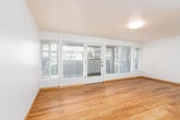 This single-floor residence offers a clean, functional layout with consistent design elements throughout. Warm hardwood flooring runs through the main living areas, lending a cohesive and inviting feel to the space. The living room is generously sized, featuring large windows fitted with blinds that allow ample natural light while maintaining privacy, with views of the surrounding outdoor environment. An additional room with hardwood flooring provides flexible use as a second living area, dining space, or home office, also benefiting from natural light through sizable windows. The galley-style kitchen is well-equipped with honey-toned wood cabinetry offering abundant storage, light countertops, a stainless steel sink, and a full suite of black and stainless steel appliances including a range, overhead microwave, refrigerator, and dishwasher. The bedroom is carpeted for comfort and features two windows that bring in natural light and views of the outdoors. The bathroom includes a full soaking tub with shower, warm wood vanity cabinetry, a light countertop, a large mirror, and chrome grab bars for added accessibility. Throughout the space, neutral wall tones and consistent flooring choices create a bright, clean ambiance well-suited for everyday living.