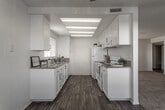 Located at 859 N Mountain Ave in Upland, California, this single-floor unit offers a well-organized layout designed for comfortable everyday living. The galley-style kitchen is a functional highlight, featuring white cabinetry with brushed gold hardware, granite-look countertops, wood-look vinyl flooring, and white appliances including a range and refrigerator. Overhead lighting illuminates the full length of the kitchen, making it a bright and practical workspace.

The living and bedroom areas are finished with neutral-toned wall-to-wall carpeting throughout, lending a warm and cohesive feel to each room. A sliding glass door fitted with vertical blinds in the main living area allows for natural light and provides access to an outdoor space. Additional bedrooms feature windows with vertical blinds, offering natural light while maintaining privacy. One bedroom includes a connected area that leads to an adjoining space, providing added flexibility.

The unit includes two bathrooms: one with a shower stall enclosed by a glass sliding door, and another with a full bathtub and shower combination. Both bathrooms feature wood-look flooring, white vanity cabinetry, and granite-look countertops, maintaining a consistent and clean aesthetic throughout the home.