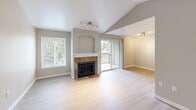 Located at 32200 Military Rd S in Federal Way, WA, this one-bedroom, one-bathroom unit offers a well-designed layout across a single floor. The open-concept living area is a standout, featuring vaulted ceilings with track lighting, light wood-style flooring, and a slate-tiled fireplace with a built-in arched niche above — creating a warm and inviting focal point. Large windows and a sliding glass door flood the space with natural light and provide direct access to a private patio. The galley-style kitchen is efficiently laid out with light wood cabinetry, stainless steel appliances including a refrigerator, microwave, range, and dishwasher, and offers a pass-through view into the living area. The bedroom is generously proportioned, featuring plush carpet, a large double-door closet, and a window with outdoor views. The full bathroom includes a tub/shower combo, a vanity with warm wood cabinetry, built-in open shelving, and wood-style flooring. Additional highlights include three closets for ample storage, a dedicated laundry area, and a transition from slate tile at the entry to light hardwood-style flooring throughout the main living spaces.
