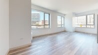 Located at 1177 Market St in the heart of San Francisco, CA, this modern single-floor residence offers a clean, contemporary design throughout. Light-toned wood-style flooring flows seamlessly across every room, creating a cohesive and airy aesthetic that complements the bright white walls and crisp trim.

The open living area is a standout feature, bathed in natural light through large floor-to-ceiling windows that frame sweeping views of the San Francisco cityscape, including recognizable civic and commercial buildings. The layout connects the living space to a well-appointed kitchen, which features dark cabinetry, a stainless steel range, and light countertops for a striking contrast.

The bedrooms are generously proportioned, each offering large windows with urban views and wall-mounted heating units. One room features a built-in closet system accessed through wide sliding louvered doors, providing ample storage with integrated shelving and drawers.

The bathroom is finished with large-format tile flooring, a dark wood double vanity with modern hardware, a white quartz countertop, and a glass-enclosed shower. Sleek brushed gold accents on the hardware and sliding barn-style door add a refined touch.

Throughout the residence, the design prioritizes clean lines, natural light, and urban connectivity, making it an ideal space in one of San Francisco's most vibrant and accessible neighborhoods.