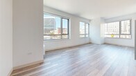 Located at 1177 Market St in the heart of San Francisco, CA, this modern single-floor residence offers a clean, contemporary design throughout. Light-toned wood-style flooring flows seamlessly across every room, creating a cohesive and airy aesthetic that complements the bright white walls and crisp trim.

The open living area is a standout feature, bathed in natural light through large floor-to-ceiling windows that frame sweeping views of the San Francisco cityscape, including recognizable civic and commercial buildings. The layout connects the living space to a well-appointed kitchen, which features dark cabinetry, a stainless steel range, and light countertops for a striking contrast.

The bedrooms are generously proportioned, each offering large windows with urban views and wall-mounted heating units. One room features a built-in closet system accessed through wide sliding louvered doors, providing ample storage with integrated shelving and drawers.

The bathroom is finished with large-format tile flooring, a dark wood double vanity with modern hardware, a white quartz countertop, and a glass-enclosed shower. Sleek brushed gold accents on the hardware and sliding barn-style door add a refined touch.

Throughout the residence, the design prioritizes clean lines, natural light, and urban connectivity, making it an ideal space in one of San Francisco's most vibrant and accessible neighborhoods.