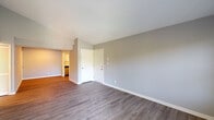 Located at 4800 Sherburn Ln in Louisville, Kentucky, this single-floor residence offers a well-designed layout with a clean, modern aesthetic throughout. The living area is bright and open, featuring dark hardwood-style flooring, soft gray walls, and access to a private balcony through a glass door, allowing natural light to fill the space. A window with blinds adds an additional source of daylight and outdoor views.

The kitchen is thoughtfully appointed with crisp white shaker-style cabinetry, granite-look countertops, a classic subway tile backsplash, and stainless steel appliances including a range, over-the-range microwave, and refrigerator — offering a polished, functional cooking space.

The bedrooms are carpeted for comfort and include ceiling fans with light fixtures. One bedroom features sliding glass door access to a balcony, while another includes a closet with louvered doors and access to a walk-in closet area, providing ample storage.

The bathroom is clean and well-appointed, featuring a vanity with white cabinetry, a large mirror with overhead lighting, and a soaking tub. A louvered closet door adjacent to the vanity provides convenient storage. Consistent use of neutral tones and quality finishes gives the entire residence a cohesive, move-in-ready feel.
