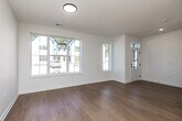 Located at 3162 Indianola Ave in Des Moines, Iowa, this two-story home offers a clean, modern aesthetic across two well-proportioned floors. The main level features an open-concept kitchen and living area bathed in natural light, with light hardwood flooring that extends throughout. The kitchen is outfitted with white shaker-style cabinetry, stainless steel appliances including a refrigerator, electric range, built-in microwave, and dishwasher, complemented by light countertops and a simple, functional layout. A full bathroom on the main level features a white vanity with an undermount sink, black hardware accents, a framed mirror, and hardwood flooring. The second floor hosts both bedrooms, each finished with plush carpet and large windows that invite ample natural light and neighborhood views. The primary bedroom includes a closet and generous floor space. A second full bathroom on this level features a tub-shower combination, white vanity, and hardwood flooring. Each floor is well-proportioned, with the upper level offering slightly more space. Crisp white walls, clean lines, and consistent finishes throughout give the home a fresh, move-in-ready appeal.