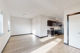 Located at 820 Trail Rd in Sedro-Woolley, Washington, this efficiently designed single-floor unit offers a clean, contemporary aesthetic throughout. Light wood-look flooring runs continuously across the space, complementing bright white walls and dark-trimmed doorways that provide a striking modern contrast.

The open-concept living area is filled with natural light, courtesy of multiple windows and a glass-paneled balcony door that frames views of the surrounding landscape, including distant mountain scenery. A wall-mounted mini-split system provides climate control, keeping the living space comfortable year-round.

The kitchen is thoughtfully laid out in a galley configuration, featuring dark espresso cabinetry with brushed hardware, white countertops, and a full suite of stainless steel appliances — including an electric range, over-the-range microwave, dishwasher, and refrigerator. Recessed lighting above the kitchen adds a polished finish.

The bathroom is clean and functional, offering a full soaking tub and shower combination with chrome fixtures set against crisp white surroundings and wood-look flooring. Throughout the unit, the design prioritizes practicality and modern style, making efficient use of every square foot in this well-appointed Sedro-Woolley residence.