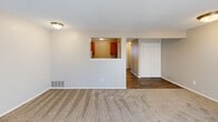 This one-bedroom, one-bathroom unit at 2722 S Topeka St in Wichita, Kansas offers a practical and comfortable layout across a single floor. The living area is generously proportioned for the footprint, featuring neutral-toned carpet, a textured ceiling, and a pass-through window that connects to the kitchen — a functional design detail that enhances the sense of openness. The kitchen is fitted with warm wood-toned cabinetry and a sink visible through the pass-through, providing an efficient workspace. The bedroom is a comfortably sized retreat, carpeted and finished with the same neutral palette found throughout the unit. It includes a double-door bifold closet offering practical storage. A hallway connects the main living areas and leads to the full bathroom, which features warm wood-toned cabinetry with brushed nickel hardware, a combined tub and shower unit, and durable wood-look flooring. Throughout the unit, clean white walls, consistent neutral tones, and textured ceilings create a cohesive, move-in-ready atmosphere. The layout flows logically, making efficient use of the available space for comfortable everyday living.
