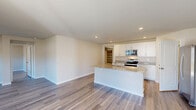 Located at 6302 Fescue Rd in Castle Hayne, NC, this single-story home offers a thoughtfully designed open-concept floor plan that seamlessly connects the living room, dining area, and kitchen into one expansive, light-filled space. The kitchen is a standout feature, showcasing crisp white shaker cabinetry, granite countertops, stainless steel appliances, a central island with a sink, and a dedicated walk-in pantry for ample storage. Recessed lighting and durable wood-look flooring flow throughout the common areas, lending a clean, modern aesthetic.

The home includes four bedrooms, each offering natural light and generous closet space — with an impressive eight closets distributed across the home. The spacious primary bedroom features its own en-suite bathroom, complete with a double-sink vanity topped with granite countertops, white cabinetry, and a glass-enclosed walk-in shower. The additional bedrooms are served by well-appointed shared bathrooms with consistent finishes.

A dedicated laundry room houses a full-size washer and dryer with overhead shelving. The home also includes an attached garage with utility space. Neutral tones, consistent flooring, and modern hardware create a cohesive and move-in-ready environment throughout.
