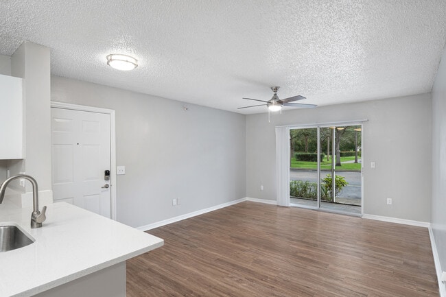 Amplia sala de estar con abundante luz natural. - Pine Lakes Preserve