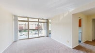 Located at 14120 Weeping Willow Dr in Silver Spring, MD, this one-bedroom, one-bathroom residence offers a practical and comfortable single-floor layout. The living room is a standout feature, boasting a large floor-to-ceiling sliding glass door that floods the space with natural light and provides pleasant views of the surrounding greenery and neighborhood. Soft carpeting throughout the living and bedroom areas adds warmth underfoot. The galley-style kitchen is efficiently designed with warm honey-toned wood cabinetry, light speckled countertops, a stainless steel sink, and white appliances including a gas range and full-size refrigerator. Wood-look flooring in the kitchen adds a clean, durable finish. The generously sized bedroom features soft carpeting, a window with natural light and exterior views, and ample closet space, including a walk-in closet. A second set of closet doors provides additional storage. The bathroom is well-appointed with a full tub and shower combination, accented by large-format stone-look tiles and chrome grab bars. Neutral, warm beige tones are carried throughout the residence, creating a cohesive and inviting atmosphere well-suited for comfortable everyday living.