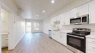 This 1-bedroom, 1-bathroom residence in San Diego, CA offers a thoughtfully designed single-level layout that maximizes its compact footprint. Light wood-style luxury vinyl flooring runs consistently throughout the unit, creating a cohesive and clean aesthetic. Recessed lighting and neutral warm-toned walls contribute to a bright, inviting atmosphere.

The open-concept kitchen and living area form the heart of the unit. The kitchen is outfitted with white shaker-style cabinetry extending to the ceiling for generous storage, complemented by a stainless steel refrigerator, electric range, over-the-range microwave, and dishwasher. A single-basin sink and light-toned countertops complete the functional workspace. The adjoining living area benefits from a sliding glass door that introduces natural light and outdoor access.

The bedroom is a well-proportioned, quiet retreat featuring a large window with vertical blinds and a closet with additional storage. The full bathroom includes a tub/shower combination with tiled surround, a white vanity with quartz-style countertop, and a recessed light overhead. A wall-mounted mini-split HVAC unit serves the living area for year-round climate control.