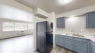 Located at 2300 Glendale Ter in Hanover Park, Illinois, this single-floor, 3-bedroom, 1-bathroom home offers a practical and well-appointed layout. The kitchen is a standout feature, showcasing stylish gray shaker-style cabinetry, light marble-look countertops, a double sink, and black appliances including a gas range and refrigerator. Light wood-style flooring runs through the kitchen and main living areas, lending a clean, cohesive look throughout.

The spacious living area benefits from large windows that allow generous natural light to fill the room, complemented by a wall-mounted air conditioning unit and baseboard heating. The generous primary bedroom offers ample room, while the additional bedrooms are comfortably sized, each featuring plush carpeting, windows with exterior views, and baseboard heating. One bedroom includes a built-in closet with a rod for convenient storage.

The bathroom is straightforward and functional, featuring tile flooring and a full tub-shower combination with tiled surround. The home's neutral color palette of whites and warm grays throughout creates a bright, move-in-ready environment well-suited for comfortable everyday living in the Hanover Park community.
