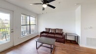 Located at 211 North Ave in Athens, GA, this single-floor residence offers a functional and well-organized layout with two bedrooms and two full bathrooms. The living room features rich hardwood-style flooring, a ceiling fan, and large windows that flood the space with natural light and provide access to a private outdoor balcony — ideal for relaxing or dining al fresco. The kitchen is thoughtfully designed with warm wood cabinetry, light marble-style countertops, stainless steel appliances including a refrigerator, microwave, and electric range, and durable hardwood-style flooring. A pass-through window connects the kitchen to the dining area, where a pendant light adds a modern touch. Both bedrooms are carpeted for comfort and include ceiling fans and sliding-door closets with built-in shelving. The primary bedroom offers a generous footprint with ample room for furnishings. Each bathroom is appointed with a walk-in shower enclosed by sliding glass doors and wood-tone vanity accents. A dedicated laundry room with a full-size washer, overhead wire shelving, and utility panel rounds out the practical amenities of this well-equipped residence.