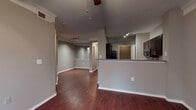 Located at 2738 Gaston Ave in Dallas, TX, this single-floor unit offers a thoughtfully designed open-concept layout that maximizes livability and flow. Rich, dark hardwood-style flooring runs throughout the main living areas, complemented by neutral gray walls and crisp white trim that create a clean, modern aesthetic.

The living area is generously proportioned, with track lighting overhead and a ceiling fan providing both function and comfort. The space opens seamlessly toward a kitchen defined by a raised peninsula with granite-style countertops, dark espresso cabinetry, and stainless steel appliances including a refrigerator and microwave. A dedicated pantry or storage closet with wire shelving sits conveniently adjacent to the kitchen, adding practical organization space.

The bedroom features plush carpeting, a ceiling fan with light fixture, and a window that brings in natural light and exterior views. It connects directly to a full bathroom equipped with a single-sink vanity featuring dark cabinetry and stone-style countertops, a soaking tub with tiled surround, and a separate walk-in closet outfitted with wire shelving. A set of French doors visible in the 3D overview suggests additional access to natural light or an exterior space. Overall, the unit combines functional design with contemporary finishes.