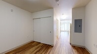 Located at 1710 Pierce St in Lakewood, Colorado, this single-floor unit offers a practical and well-appointed layout across two living areas and one bathroom. Throughout the space, warm wood-tone flooring provides a cohesive and inviting foundation, complementing the clean white walls that create a bright, open atmosphere.

The primary living area is generously proportioned and benefits from natural light streaming in through a large window fitted with blinds. A ceiling fan overhead aids in air circulation, while a wall-mounted HVAC unit ensures year-round climate control. The second living area features a built-in sliding closet, offering convenient storage, and is similarly finished with the same warm flooring and neutral walls.

The bathroom is designed with accessibility in mind, equipped with grab bars and a roll-in style walk-in shower featuring a low-threshold base and a handheld showerhead. A wood-cabinet vanity with a white countertop and mirror completes the space, adding a touch of warmth and functionality.

Overall, the unit presents a clean, minimalist aesthetic with consistent finishes throughout. The layout is straightforward and efficient, making it well-suited for a variety of occupants seeking a comfortable and accessible living environment in the Lakewood area.