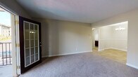 Located at 150 Chateau Trail in Athens, GA, this single-story 1-bedroom unit offers a practical and comfortable layout designed for everyday living. The living room is a generously sized, carpeted space with neutral beige walls, a textured ceiling, and a grid-paned exterior door that allows natural light to filter in. The open sightline from the living area leads into the dining and kitchen zones, creating a connected flow throughout the unit. The kitchen is a standout feature, showcasing rich dark wood cabinetry, light granite countertops, a classic white subway tile backsplash, a stainless steel range, and a brushed nickel faucet at the undermount sink. The bedroom is a comfortable, carpeted retreat with a ceiling fan, a window overlooking the exterior, and clean white baseboards throughout. Flooring transitions from plush carpet in the living and sleeping areas to hard surface flooring in the kitchen and entry zones. The bathroom is clean and functional, featuring a full tub and shower combination with white tile surround, and polished chrome fixtures. Overall, the unit presents a cohesive, move-in-ready aesthetic with neutral tones and practical finishes throughout.