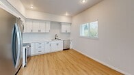 Located at 8801 Copperstone Ave SW in Lakewood, WA, this thoughtfully designed 2-bedroom, 2-bathroom unit offers a clean, modern aesthetic throughout its well-utilized single-floor layout. Light wood-tone vinyl flooring flows seamlessly across all living areas, complemented by crisp white walls and consistent black hardware accents that lend a contemporary feel. The open kitchen and living area serves as the heart of the home, featuring white shaker-style cabinetry, white quartz countertops, a stainless steel sink with a matte black faucet, and a full suite of stainless steel appliances including a refrigerator, electric range, over-the-range microwave, and dishwasher. Natural light fills the space through multiple windows with horizontal blinds, offering views of the surrounding greenery. The primary bedroom is a comfortable retreat with a dedicated closet, while the second bedroom also includes a closet and its own window with outdoor views. Both bathrooms are finished in a clean, modern style — the primary bathroom features a wide vanity with a large mirror and contemporary lighting, while the second bathroom includes a tub/shower combo. Additional highlights include four closets for generous storage, a dedicated laundry area, a hallway with utility access, and a private patio.