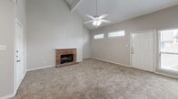 Located at 11240 Perry Rd in Houston, TX, this multi-story home offers 2 bedrooms and 3 bathrooms across three floors. The main living level serves as the heart of the home, where a dramatic vaulted ceiling with an exposed beam and ceiling fan crowns a spacious living room anchored by a classic brick fireplace. Neutral carpet flooring flows throughout the living areas, complementing the soft, neutral wall tones. Natural light enters through well-placed windows, adding to the open, airy feel. The adjacent kitchen is well-appointed with warm wood cabinetry, granite-look countertops, a central island for additional prep space, tile flooring, and white appliances including a range, microwave, dishwasher, and refrigerator. The dining area connects seamlessly to the kitchen and living space. Both bedrooms are carpeted and include ceiling fans; the primary bedroom features a private en-suite bathroom with a wood-toned vanity and granite countertop. Additional bathrooms include a tiled tub-shower combination. Multiple closets and pantry spaces provide ample storage throughout. The attached garage offers a clean, epoxy-coated floor and automatic opener. Multiple staircases connect the three levels efficiently, completing this functional and comfortable Houston home.
