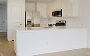 This contemporary single-story home in New Caney, TX offers 1,160 square feet of thoughtfully designed living space. The property features three bedrooms, including a spacious 170 sq ft primary bedroom, and two full bathrooms. The open-concept layout seamlessly integrates the kitchen and living areas, promoting a sense of spaciousness and connectivity.

The kitchen boasts modern white cabinetry, stainless steel appliances, and a sleek countertop with a built-in sink. Large windows throughout the home allow for ample natural light, creating a bright and airy atmosphere. The bedrooms are generously sized, with the primary bedroom featuring an en-suite bathroom and walk-in closet.

Flooring varies throughout the home, with light-colored wood-look flooring in the main living areas and plush carpeting in the bedrooms. The bathrooms are outfitted with contemporary fixtures and finishes, including a combination tub-shower unit.

The property includes a garage with an automatic door opener, providing secure parking and additional storage space. The exterior features a combination of brick and siding, with a manicured front yard and a concrete driveway. Located in a well-maintained neighborhood, this home offers a perfect blend of modern comfort and practical living space.