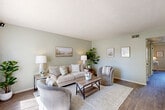 Located in Goodyear, Arizona, this well-appointed 2-bedroom, 1-bathroom single-story home offers a cohesive and inviting design throughout. A consistent soft sage-green color palette ties every room together, complemented by wood-look flooring that flows through the main living areas.

The living room is the heart of the home, featuring a textured ceiling, a large window that fills the space with natural light, and ample room for comfortable seating arrangements. Adjacent to it, the compact kitchen is efficiently designed with white cabinetry, light countertops, a double-basin sink, and white appliances — maximizing both storage and functionality.

The primary bedroom offers a comfortable retreat with tile flooring, a ceiling fan, a closet, and a door providing direct outdoor access. The second bedroom features wood-look flooring, a ceiling fan, and a full-width sliding closet, offering practical storage. Both rooms carry the same calming sage-green wall tones found throughout the home.

The shared full bathroom is clean and functional, outfitted with a tub-shower combination, a single-sink vanity with white cabinetry, and wood-look flooring. A hallway connects the rooms, keeping the layout straightforward and easy to navigate. This home delivers a warm, cohesive aesthetic well-suited for comfortable everyday living in the Goodyear, AZ area.
