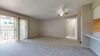 Located at 3488 W Quincy Ave in Sheridan, CO, this 1-bedroom, 1-bathroom residence offers a practical and comfortable single-floor layout. The open-concept living room is generously sized, featuring soft carpeting, neutral-toned walls, a textured ceiling, and a ceiling fan with light fixture. A sliding glass door leads to a private balcony overlooking a well-maintained courtyard with mature trees and landscaped grounds, bringing in abundant natural light. The kitchen is thoughtfully designed with white cabinetry, granite-style countertops, wood-look flooring, and a full suite of white appliances including a range, refrigerator, and dishwasher. A pantry closet provides additional storage within the kitchen. The bedroom is a comfortable retreat, carpeted and bright, with a window allowing natural light and access to a dedicated walk-in closet fitted with multi-level shelving rods. The full bathroom features wood-look flooring, a tub-shower combination, a vanity with a granite-style countertop, and clean white finishes throughout. A wall-mounted HVAC unit in the living area provides climate control. The overall ambiance is clean, neutral, and move-in ready, suited for efficient and comfortable everyday living.
