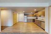 Located at 15911 Admiralty Way in Lynnwood, WA, this well-appointed three-bedroom, two-bathroom residence offers a thoughtfully designed single-level layout. The open-concept living, dining, and kitchen area serves as the heart of the home, featuring warm hardwood-style flooring that creates a seamless flow throughout. The modern kitchen is equipped with stainless steel appliances—including a refrigerator, range, and microwave—complemented by contemporary wood-grain cabinetry and light quartz countertops that provide generous prep and storage space. The living area transitions to plush carpeting, with natural light streaming in through large windows that offer views of the surrounding community. Each of the three bedrooms is carpeted and well-proportioned, with the spacious primary bedroom offering ample room for a full furniture arrangement. Five closets throughout the unit provide exceptional storage. Both bathrooms feature a clean, modern aesthetic with wood-look tile flooring and tub-shower combinations. A dedicated in-unit laundry room houses a full-size Whirlpool washer and dryer, adding everyday convenience. The neutral color palette and modern finishes throughout create a bright, move-in-ready atmosphere.
