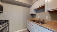 Located at 1691 Red Robin St in Columbus, Ohio, this two-floor home offers a practical and well-organized layout across both levels. The main floor features a welcoming living area with light-toned luxury vinyl plank flooring, neutral taupe walls, and a front entry door flanked by a staircase leading to the upper level. Natural light filters in through windows, giving the main living space an open, airy feel.

The kitchen is equipped with white cabinetry, both upper and lower, providing ample storage alongside a double-basin stainless steel sink set into a tan countertop. A dedicated space is also present with utility hookups, including plumbing and electrical connections beneath a sloped ceiling, suitable for laundry appliances.

One of the rooms on the main level features sliding glass doors with vertical blinds, a ceiling fan with light fixture, and direct access to an outdoor area. Upstairs, the bedrooms are carpeted and feature neutral-toned walls, with one room offering a sliding-door closet with built-in shelving. An additional carpeted bedroom provides a quiet, comfortable space.

The full bathroom includes a tiled shower-tub combo, a white vanity with storage, a medicine cabinet mirror, and light vinyl flooring. Throughout the home, consistent neutral tones and clean finishes create a cohesive, move-in-ready environment.