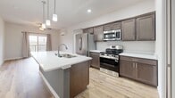 This contemporary 870 square foot apartment offers a thoughtful layout with 3 bedrooms and 2 bathrooms. The heart of the home is a sleek, open-concept kitchen featuring stainless steel appliances, dark wood cabinetry, and a spacious island with a white quartz countertop. Pendant lighting adds a touch of modern elegance.

The living areas boast beautiful hardwood floors, while the bedrooms are comfortably carpeted. Large windows in each room flood the space with natural light, and mini-split air conditioning units ensure year-round comfort. The bathrooms showcase clean lines with wood vanities and ample storage.

A standout feature is the primary bedroom, measuring 130 square feet. The apartment also includes a practical closet space with wire shelving for organization. Throughout the home, neutral tones create a calm and inviting atmosphere, perfect for personalizing to your taste.

Located in Fitchburg, WI, this single-story apartment combines functionality with contemporary style, offering a comfortable living space in a convenient location.