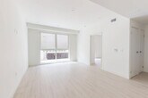 Located on Victory Blvd in Los Angeles, this modern 2-bedroom, 1-bathroom unit offers a thoughtfully designed single-floor layout with clean, contemporary finishes throughout. Light wood-tone flooring runs continuously across the open-concept living and kitchen area, creating a bright and cohesive feel. The kitchen is well-appointed with rich walnut-toned cabinetry, stainless steel appliances including a range and refrigerator, light quartz countertops, and recessed lighting overhead. The open living area flows naturally from the kitchen, offering a spacious and airy environment with recessed lighting and large windows that invite generous natural light. Both bedrooms feature the same light wood flooring and crisp white walls. The primary bedroom includes floor-to-ceiling windows overlooking an outdoor patio area, while the second bedroom features a mirrored sliding-door closet. Two closets provide ample storage throughout the unit. The bathroom is finished with sleek, modern materials, including large-format marble-look tile, a glass-enclosed walk-in shower with a sliding door, and concrete-style flooring, offering a refined, spa-like atmosphere. The overall design aesthetic is minimalist and contemporary, emphasizing clean lines, neutral tones, and functional living spaces.