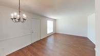 This single-floor residence in the Village offers a clean, functional layout designed for comfortable everyday living. The entryway opens into a spacious living area featuring warm hardwood-style flooring, crisp white walls, and a wall sconce that adds a touch of classic charm. Natural light filters in through a front-facing window, creating a bright and welcoming atmosphere. A chandelier marks the transition into the dining area, which connects seamlessly to the kitchen through a convenient pass-through counter.

The kitchen is well-equipped with rich wood cabinetry extending to the ceiling, white tile backsplash, light stone countertops, a double-basin sink, a coil-top electric range, and a built-in microwave. A window above the sink allows for natural light while cooking. The hardwood-style flooring continues throughout, tying the spaces together cohesively.

The bedroom is a comfortable, light-filled room with a large window fitted with blinds. A standout feature is the dual closet configuration, offering generous storage with two side-by-side closets, each with a full-width hanging rod.

The full bathroom features classic white hexagonal tile flooring, a single-vanity with wood cabinetry, a toilet, and a shower-tub combination with built-in cabinetry above for additional storage. A window provides ventilation and natural light.