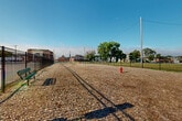 Located at 8 South 6th Street in Council Bluffs, Iowa, this open-air lot offers a level, single-story parcel situated within an established urban neighborhood. The ground is uniformly covered with wood chip material, providing a stable and low-maintenance surface across the entirety of the space. A sturdy black iron perimeter fence encloses the lot, clearly defining its boundaries and providing a sense of security and structure.

The surrounding environment offers a rich context, with several notable brick buildings visible from within the lot, including what appears to be a multi-story institutional or commercial structure to the north and a smaller historic brick building to the east. The neighborhood reflects a mix of commercial and civic land uses, with additional structures, utility poles, and mature trees visible in multiple directions.

Marker stakes are visible throughout the lot, suggesting active planning or development potential. A fire hydrant is present on the interior of the lot, indicating established utility infrastructure. The space benefits from abundant natural light under open skies, with unobstructed views in several directions. The lot's central location within the Council Bluffs urban core, combined with its existing fencing and utilities, positions it as a versatile site suitable for a range of development or community use applications.