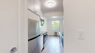 Located at 286 Finch Avenue West in North York, Toronto, this thoughtfully updated 2-bedroom, 1-bathroom unit offers a clean, modern aesthetic throughout. Light-toned hardwood-style flooring runs continuously across the entire floor plan, lending warmth and visual cohesion to every room.

The open living area is bright and airy, with multiple windows framing lush, tree-lined views and classic cast-iron radiators providing efficient, radiant heating. The space offers a comfortable and versatile layout suitable for both relaxing and entertaining.

The galley-style kitchen is well-appointed with white cabinetry, dark countertops, a subway tile backsplash, and a full suite of stainless steel appliances including a range, microwave, dishwasher, and refrigerator — combining a clean, contemporary look with practical functionality.

Both bedrooms are finished with the same light flooring and crisp white walls. The primary bedroom features a window with serene greenery views and a radiator, while the second bedroom offers a calm, neutral palette with easy access to hallway storage.

The bathroom is finished with classic white subway tile surrounding the bathtub and shower, complemented by grey floor tiles, a vanity with storage, and clean chrome fixtures — creating a timeless, polished look. Two hallways provide additional circulation and storage options throughout the unit.
