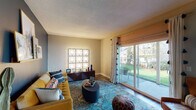 Located at 4200 SW 107th Ave in Beaverton, Oregon, this single-floor residence offers a thoughtfully designed layout with a welcoming and eclectic aesthetic. The living area serves as the heart of the home, featuring rich hardwood-style flooring, a bold accent wall, and large sliding glass doors that flood the space with natural light and open directly onto a private patio overlooking a lush green yard. The kitchen is outfitted with crisp white cabinetry, light countertops, and stainless steel appliances including a dishwasher and refrigerator, all complemented by durable wood-look flooring. Two bedrooms provide comfortable retreats, each with plush carpeting, closet storage, and windows that bring in natural light. The primary bedroom includes a spacious reach-in closet, while both rooms offer a calm, restful atmosphere. The bathroom features dual vanity areas with white cabinetry, brushed nickel fixtures, and well-lit mirrors, providing a clean and functional space. Throughout the residence, a mix of warm and cool tones, textured rugs, and eclectic decor details contribute to a vibrant yet comfortable living environment ideal for everyday life in Beaverton.