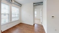 This 2-bedroom, 2-bathroom unit is thoughtfully laid out across a single floor, blending functional design with contemporary finishes. The open living and kitchen area features durable wood-look flooring and a striking industrial touch with exposed cylindrical ductwork running along the upper walls, adding character to the otherwise clean, white interior. Large windows allow natural light to fill the space, enhancing its airy feel.

The kitchen is well-appointed with gray shaker-style cabinetry, granite-look countertops, a stainless steel sink, and a full suite of black appliances including a range, microwave, dishwasher, and refrigerator. Ample upper and lower cabinet storage makes this kitchen as practical as it is attractive.

Both bedrooms are comfortably sized, with soft carpeting underfoot and natural light from windows. One bedroom features an industrial ductwork accent similar to the main living area, while both offer closet access. The neutral walls create a versatile backdrop adaptable to any style.

The two bathrooms are clean and functional. One features a full soaking tub with a curved shower rod and tile flooring, while the other includes a vanity with granite-look countertops, a dark wood cabinet base, and a lighted mirror. Both bathrooms maintain a consistent, polished aesthetic throughout the unit.
