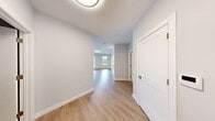 Located at 1 Crown Dr in Quincy, MA, this well-appointed two-bedroom, one-bathroom residence offers a thoughtfully designed single-floor layout with a clean, modern aesthetic throughout. Light gray walls, crisp white trim, and smooth hardwood-style flooring create a bright and cohesive atmosphere across all rooms.

The open-concept kitchen and living area serves as the heart of the home. The kitchen is outfitted with white shaker-style cabinetry, light quartz countertops, a peninsula with bar seating, stainless steel appliances including a refrigerator, range, microwave, and dishwasher, and pendant lighting that adds a warm, contemporary touch. The adjoining living room is generously proportioned, featuring multiple windows and a glass-panel door that invite abundant natural light and views of the surrounding community.

The spacious primary bedroom benefits from a large picture window overlooking greenery and the neighborhood streetscape. The second bedroom is a well-sized, versatile space with the same consistent flooring and soft neutral tones. The bathroom features tile flooring in a natural wood-look pattern and a clean, minimalist design. The overall ambiance is fresh, modern, and move-in ready, making this residence a comfortable and functional home in Quincy.