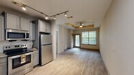 Located on Reames Road in Charlotte, NC, this single-floor, one-bedroom, one-bathroom residence offers a well-organized layout designed for comfortable everyday living. Light wood-style flooring runs throughout the home, creating a cohesive and clean aesthetic from room to room.

The kitchen is a standout feature, outfitted with gray shaker-style cabinetry, granite countertops, a classic subway tile backsplash, and a full suite of stainless steel appliances including a refrigerator, range, over-the-range microwave, and dishwasher. The space is both functional and visually appealing.

The living area is open and airy, with neutral-toned walls and a ceiling fan overhead. The space flows naturally and benefits from a clean, minimalist design that offers flexibility for various furniture arrangements.

The bedroom is a comfortable size, featuring a ceiling fan, a window with views of surrounding greenery, and warm neutral walls that contribute to a calm, restful atmosphere. A dedicated closet provides practical storage.

The bathroom is neatly appointed with a white vanity, granite countertop, and a tub-shower combination. Continuing the home's consistent flooring, the bathroom maintains the same light, fresh tone found throughout.

A dedicated laundry area with a full-size washer and overhead shelving adds further convenience to this well-rounded Charlotte residence.
