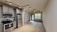 Located on Reames Road in Charlotte, NC, this single-floor, one-bedroom, one-bathroom residence offers a well-organized layout designed for comfortable everyday living. Light wood-style flooring runs throughout the home, creating a cohesive and clean aesthetic from room to room.

The kitchen is a standout feature, outfitted with gray shaker-style cabinetry, granite countertops, a classic subway tile backsplash, and a full suite of stainless steel appliances including a refrigerator, range, over-the-range microwave, and dishwasher. The space is both functional and visually appealing.

The living area is open and airy, with neutral-toned walls and a ceiling fan overhead. The space flows naturally and benefits from a clean, minimalist design that offers flexibility for various furniture arrangements.

The bedroom is a comfortable size, featuring a ceiling fan, a window with views of surrounding greenery, and warm neutral walls that contribute to a calm, restful atmosphere. A dedicated closet provides practical storage.

The bathroom is neatly appointed with a white vanity, granite countertop, and a tub-shower combination. Continuing the home's consistent flooring, the bathroom maintains the same light, fresh tone found throughout.

A dedicated laundry area with a full-size washer and overhead shelving adds further convenience to this well-rounded Charlotte residence.