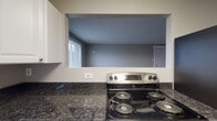 Located at 2143 Winslow Dr in Columbus, Ohio, this single-floor home offers a practical and comfortable layout with a clean, neutral aesthetic throughout. The kitchen is well-appointed with white cabinetry, dark granite-style countertops, stainless steel appliances including an electric range and refrigerator, and light wood-look flooring. A pass-through window connects the kitchen to the living area, promoting an open feel and allowing natural light to flow between spaces. The spacious living area features plush carpeting, light gray walls, a window unit for climate control, and a large window fitted with blinds that invites natural light. The bedrooms are carpeted and finished with neutral gray tones, each featuring windows with blinds and baseboard heating. One bedroom includes a dedicated closet with a built-in rod for added storage convenience. The full bathroom is efficiently designed with a tub-shower combination, a single vanity, toilet, and a frosted window above the tub for natural light and privacy. Textured ceilings are consistent throughout the home, adding a subtle design element. The overall ambiance is clean, functional, and move-in ready, making this Columbus residence a straightforward and well-maintained living space.