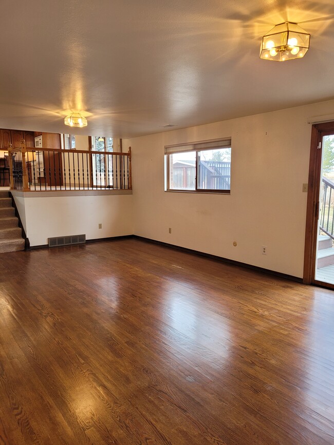 Family room with wet bar and hardwood floors, sliding door opens to lower deck and backyard - 9637 W Ohio Ave