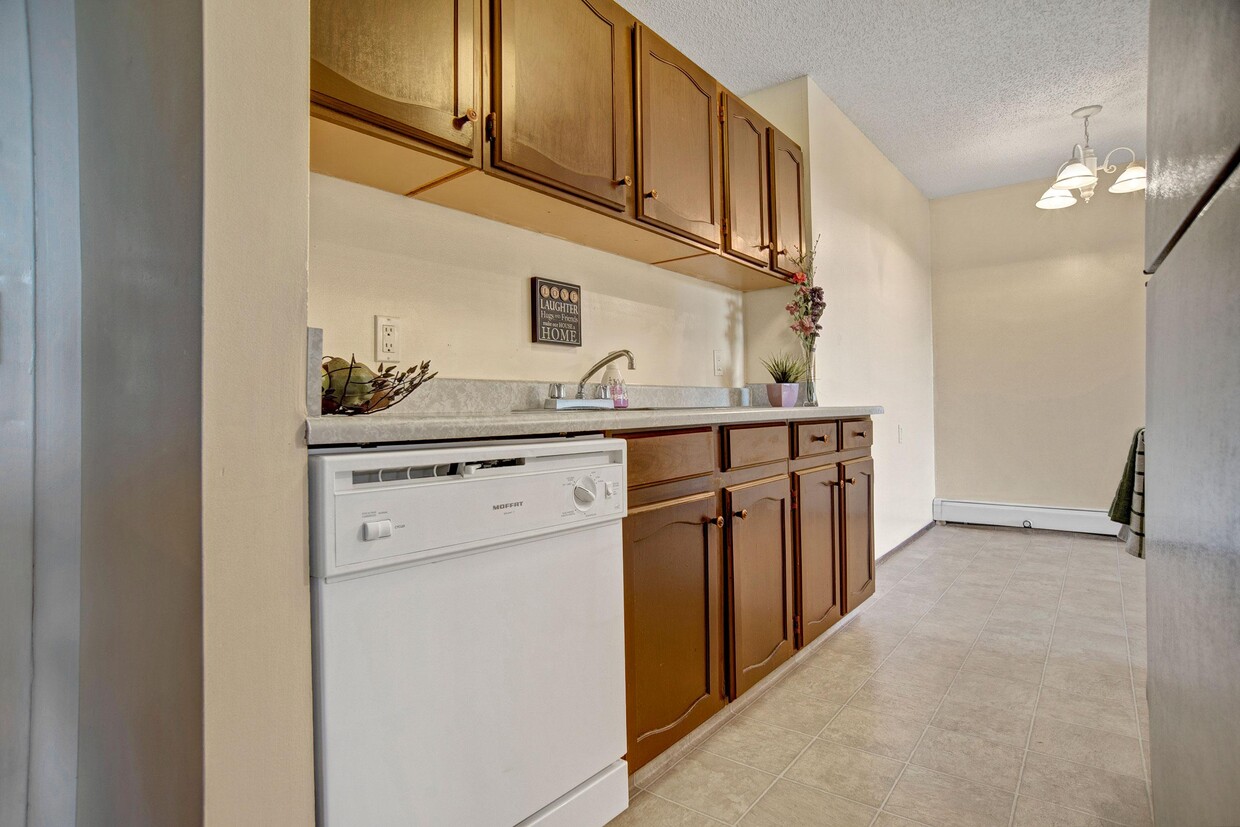 A kitchen with white appliances and dark cabinetry - Ventana