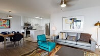 Located at 1020 Chesapeake Drive in Havre De Grace, Maryland, this single-floor residence offers a thoughtfully designed open-concept layout that promotes a seamless flow between living and dining areas. The living space features warm hardwood-style flooring, a ceiling fan with brass-toned fixtures, and neutral white walls that create a bright, welcoming atmosphere. Colorful abstract artwork and eclectic furnishings, including a bold teal accent chair and a gray sofa, contribute a modern, curated feel.

The kitchen is a standout feature, outfitted with crisp white cabinetry, a classic subway tile backsplash, light quartz countertops, and a full suite of stainless steel appliances including a gas range, microwave, dishwasher, and refrigerator. A skylight overhead fills the kitchen with natural light, while a central island provides additional prep and casual dining space.

The bedroom is a comfortable retreat with plush carpeting, a ceiling fan, a natural-light window, and access to a generously sized walk-in closet equipped with wire shelving. The bathroom features tile flooring, a white vanity with under-cabinet storage, and gold-toned hardware accents that complement the home's warm design details throughout.