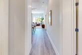 Located at 225 Canal St in Lemont, IL, this thoughtfully designed 2-bedroom, 1-bathroom residence offers a clean, modern aesthetic across a single level. Light hardwood-style flooring runs throughout, complemented by crisp white walls and recessed lighting that create a bright, welcoming atmosphere.

The open-concept kitchen and living area form the heart of the home. The kitchen features white shaker upper cabinets, contrasting blue-gray lower cabinets, a white quartz countertop, stainless steel appliances, and a central island with bar seating — ideal for casual dining or entertaining. The adjacent living room benefits from large windows that flood the space with natural light and offer views to the outdoors.

A clean hallway connects the private areas of the residence. The spacious primary bedroom includes generous windows that bring in ample daylight. Both bedrooms feature the same consistent hardwood-style flooring and neutral tones that define the rest of the home.

The bathroom is a standout feature, showcasing marble-look tile flooring, a deep soaking tub with herringbone-tiled surround, a large vanity with dark cabinetry, white quartz countertop, gold hardware accents, and a wide mirror. A dedicated closet and well-planned layout round out this efficiently organized and stylishly finished residence.