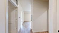 This thoughtfully designed 2-bedroom, 1-bathroom unit in Wausau, Wisconsin offers a clean, modern aesthetic across its single floor. Light wood-tone flooring runs consistently throughout, creating a cohesive and inviting atmosphere from room to room.

The kitchen is a standout feature, outfitted with contemporary taupe cabinetry accented by matte black hardware and bright white quartz countertops. Stainless steel appliances — including a refrigerator, range, and microwave — add a polished touch, while a peninsula with an undermount sink provides additional prep space and subtle separation from the living area. Stylish black pendant lights hang overhead, complementing recessed ceiling lighting for a well-lit, functional workspace.

The primary bedroom is a comfortable and quiet retreat, featuring a closet with louvered doors, a large window that brings in natural light and outdoor views, and a ceiling vent for climate control. The second bedroom is similarly bright and functional, with clean white walls, wood-look flooring, and a transom-style window that admits additional light.

The full bathroom is neatly finished with a single-sink vanity topped with a white countertop, warm wood cabinetry, a framed mirror with globe lighting, and a full tub-shower combination. Throughout the unit, neutral tones and modern finishes create a clean, move-in-ready environment suited for comfortable everyday living.