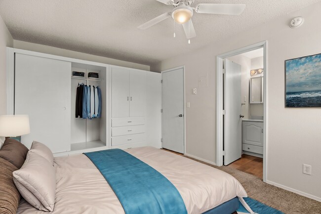 Dormitorio acogedor y funcional, con decoración virtual que destaca el almacenamiento integrado, la moqueta suave y un diseño limpio y moderno. - Highland Court Apartments
