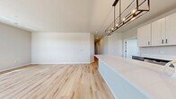 This 1,090-square-foot single-story residence at 930 Terrapin Ln, Unit 103, features 2 bedrooms, 2 bathrooms, and an attached garage. Light wood-look luxury vinyl plank flooring flows throughout the main living areas, complemented by neutral walls that create a bright, cohesive aesthetic. The open-concept kitchen and living room is a standout, featuring white shaker-style upper cabinets, two-tone gray lower cabinets with matte black hardware, quartz countertops, a large center island, and stainless steel appliances. Multiple windows in the living area admit generous natural light and outdoor views. The primary bedroom spans 170 square feet and is carpeted for comfort, with a ceiling fan, a large window, and access to a private en-suite bathroom equipped with a walk-in shower featuring sliding glass doors with black framing and light wood-look flooring. The second bathroom offers a full tub-shower combo, a gray vanity with a white countertop, and a large mirror. The secondary bedroom is also carpeted and includes a ceiling fan and window. Two closets provide ample storage. The attached garage is spacious with a panel-style door, an automatic opener, and concrete flooring.