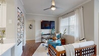 This thoughtfully designed single-story residence offers two bedrooms and two bathrooms within a efficient and well-organized floor plan. The living room serves as a welcoming centerpiece, featuring crown molding, a ceiling fan, rich hardwood-style flooring, and large windows dressed with sheer curtains and blinds that invite generous natural light. An elegant arched doorway adds architectural character and connects the living area to the rest of the home.

The kitchen is outfitted with white shaker cabinetry, quartz countertops, a peninsula with additional prep space, stainless steel appliances, and a marble-style tile backsplash — combining both functionality and style. Hardwood-style flooring continues throughout this space.

The primary bedroom is a comfortable retreat, featuring plush carpet, large windows with outdoor views, and ample wall space. The second bedroom mirrors this warmth with dual windows and soft carpet flooring. Both bathrooms are finished with white vanity cabinetry, quartz countertops, framed mirrors, and tub-shower combinations. One bathroom showcases a marble-patterned shower curtain, adding an elegant touch.

Additional highlights include a dedicated hallway, a closet for storage, and recessed lighting throughout, making this a complete and move-in-ready residence.